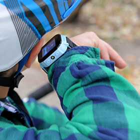 Smartwatch dla dzieci w kolorze niebieskim z funkcją telefonu na ręku dziecka, który przykłada go do ucha